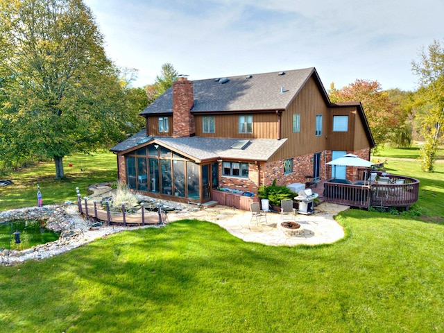 4508 Mccauley Rd, Woodstock, IL 60098 - back of property featuring a sunroom, a fire pit, a chimney, a wooden deck, and a patio