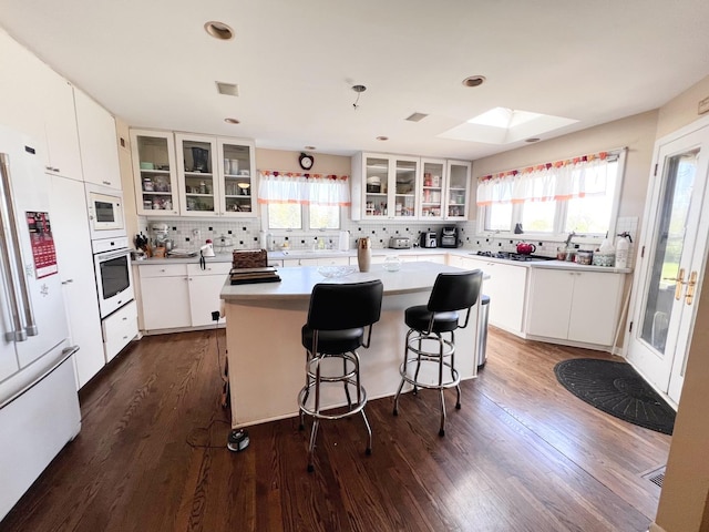 4508 Mccauley Rd, Woodstock, IL 60098 - kitchen featuring white appliances, tasteful backsplash, a skylight, healthy amount of natural light, and recessed lighting