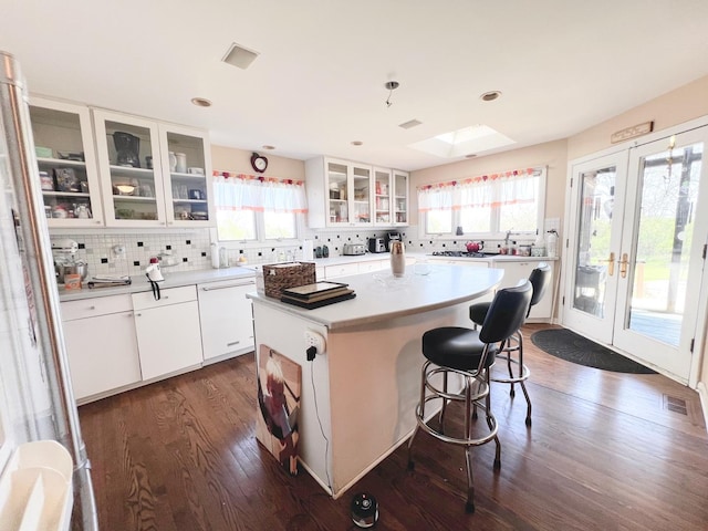 4508 Mccauley Rd, Woodstock, IL 60098 - kitchen featuring decorative backsplash, a skylight, dark wood finished floors, a kitchen island, and white cabinets
