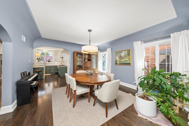 946 N Marion St, Oak Park, IL 60302 - dining area featuring arched walkways, dark wood-type flooring, and baseboards