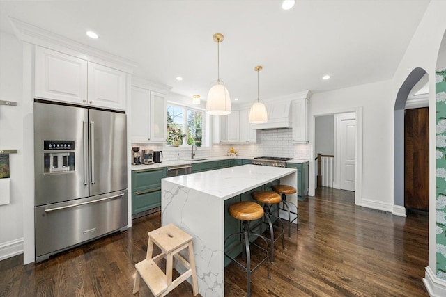 946 N Marion St, Oak Park, IL 60302 - kitchen with appliances with stainless steel finishes, arched walkways, a sink, tasteful backsplash, and dark wood finished floors