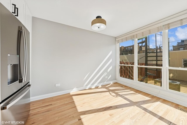 interior space with baseboards and light wood-type flooring