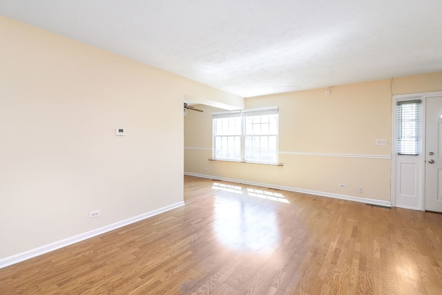 empty room featuring baseboards and light wood-style flooring