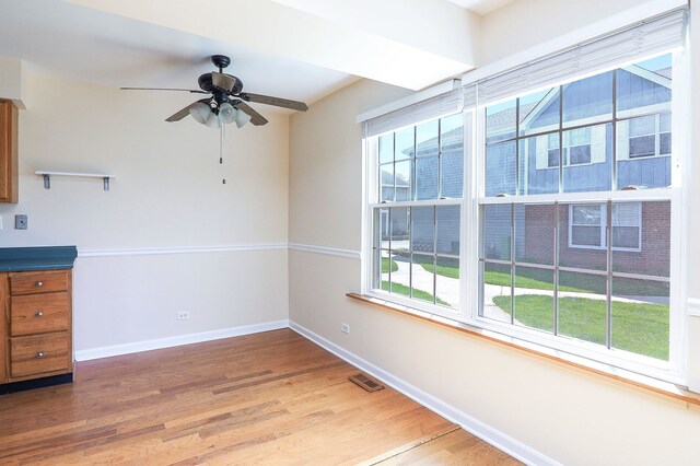unfurnished dining area with light wood-type flooring, baseboards, and ceiling fan