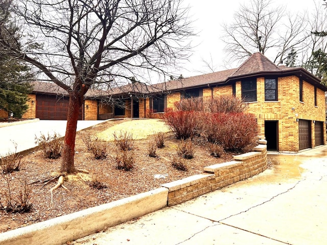ranch-style home featuring an attached garage, brick siding, and driveway