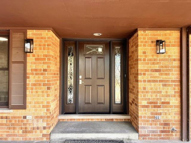 view of exterior entry with brick siding