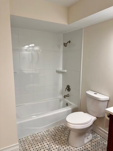 full bath featuring toilet, tile patterned flooring, vanity, and washtub / shower combination