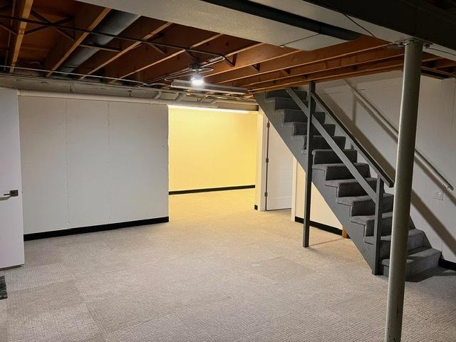 finished below grade area with stairs and light carpet