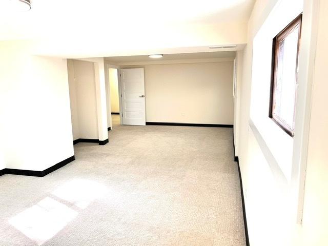 carpeted empty room with baseboards