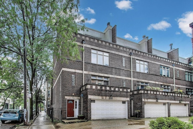 1214 N Marion Ct Unit A, Chicago, IL 60622 - view of front of house with brick siding, an attached garage, and driveway