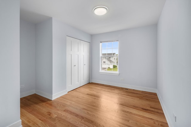 20445 Spirea Ln, Crest Hill, IL 60403 - unfurnished bedroom featuring a closet, light wood-type flooring, and baseboards