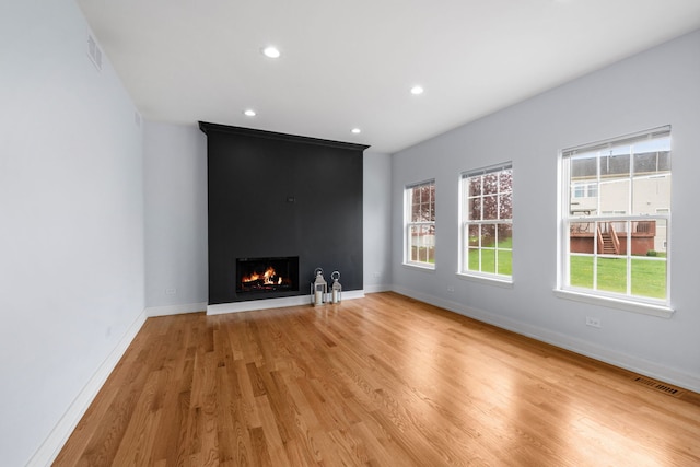 20445 Spirea Ln, Crest Hill, IL 60403 - unfurnished living room with a large fireplace, light wood finished floors, baseboards, and visible vents