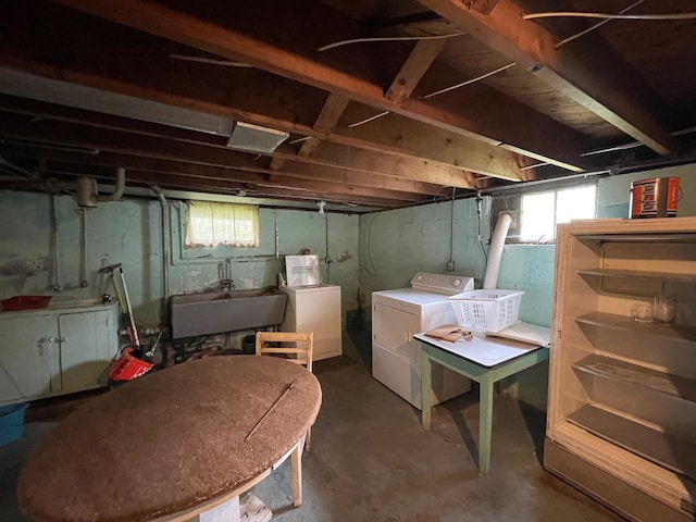 basement featuring washing machine and dryer, a sink, and plenty of natural light