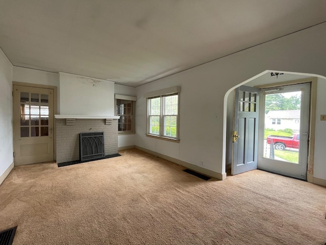 unfurnished living room with carpet flooring, baseboards, and a fireplace
