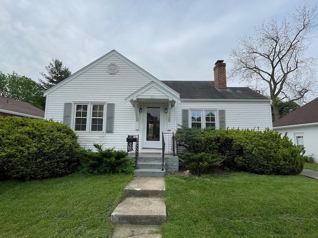 view of front of home featuring a chimney and a front yard