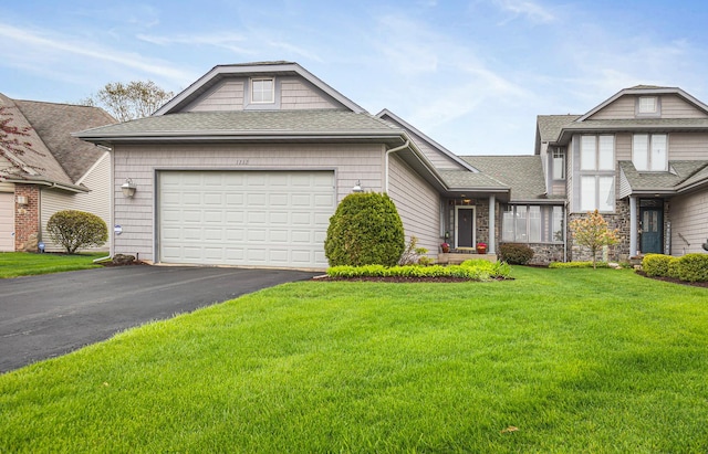 view of front of home featuring a front lawn, roof with shingles, an attached garage, and aphalt driveway