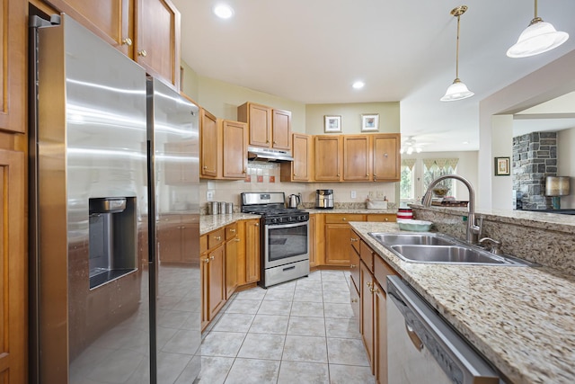 kitchen featuring a sink, stainless steel appliances, decorative light fixtures, under cabinet range hood, and decorative backsplash