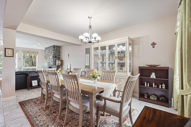 dining room featuring an inviting chandelier, marble finish floor, and a fireplace