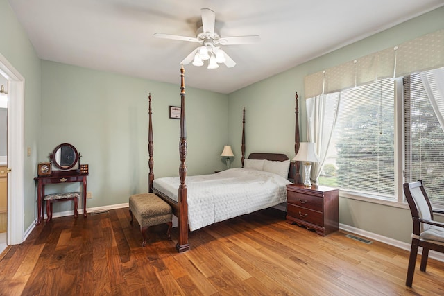 bedroom with multiple windows, ceiling fan, visible vents, and wood finished floors