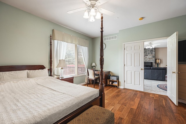 bedroom with baseboards, ceiling fan, visible vents, and wood finished floors