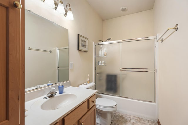 full bathroom with tile patterned floors, toilet, bath / shower combo with glass door, and vanity