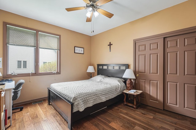 bedroom with wood finished floors, a ceiling fan, a closet, visible vents, and baseboards