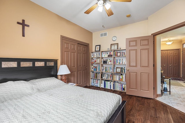 bedroom featuring ceiling fan, a closet, visible vents, and wood finished floors