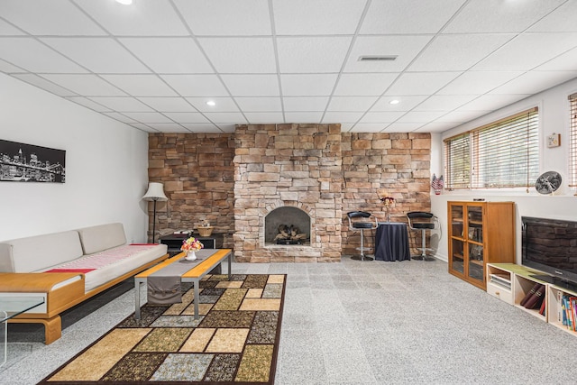 carpeted living room featuring a fireplace, recessed lighting, visible vents, and a drop ceiling