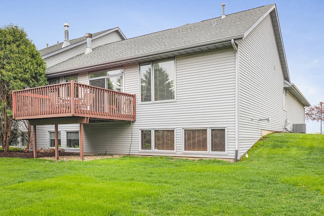 rear view of property featuring a yard, central AC unit, a wooden deck, and roof with shingles