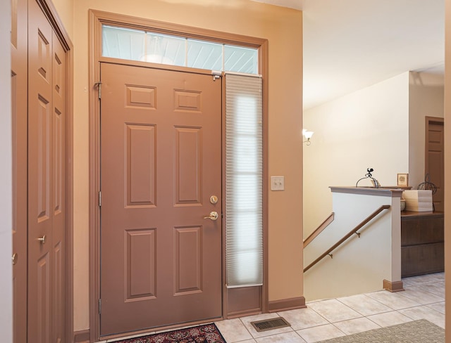 foyer featuring light tile patterned floors, baseboards, and visible vents