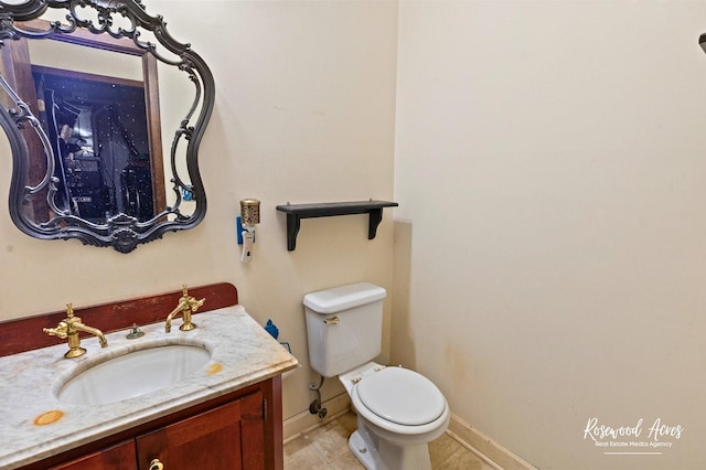 bathroom featuring baseboards, tile patterned flooring, vanity, and toilet
