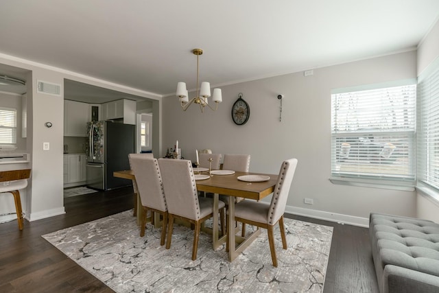 dining area with an inviting chandelier, ornamental molding, dark wood-style floors, and visible vents