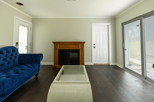 living area with crown molding, dark wood-type flooring, a fireplace, and a healthy amount of sunlight