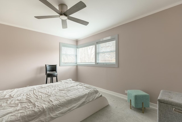 carpeted bedroom with ceiling fan, ornamental molding, and baseboards