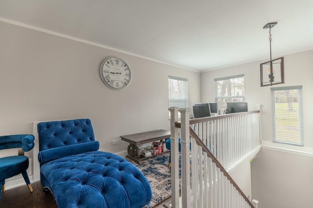 sitting room with wood finished floors, an upstairs landing, baseboards, and ornamental molding
