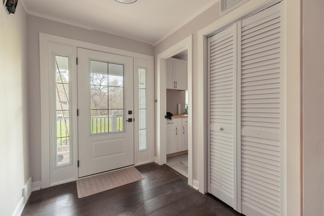 foyer entrance with baseboards, dark wood-type flooring, and visible vents