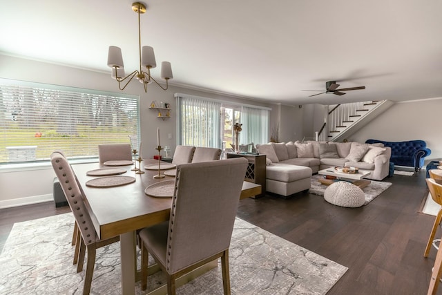 dining area featuring crown molding, stairs, ceiling fan with notable chandelier, and dark wood-style floors