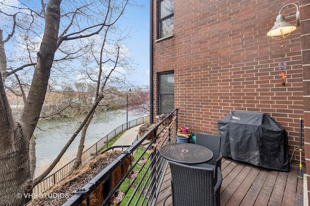 wooden deck featuring a water view and area for grilling