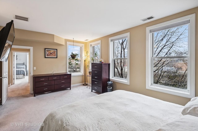 bedroom with visible vents, baseboards, and light carpet