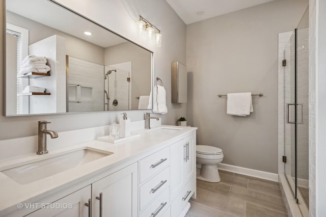 full bath with double vanity, a shower stall, and a sink