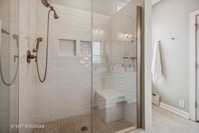 bathroom with baseboards, a shower stall, and tile patterned floors