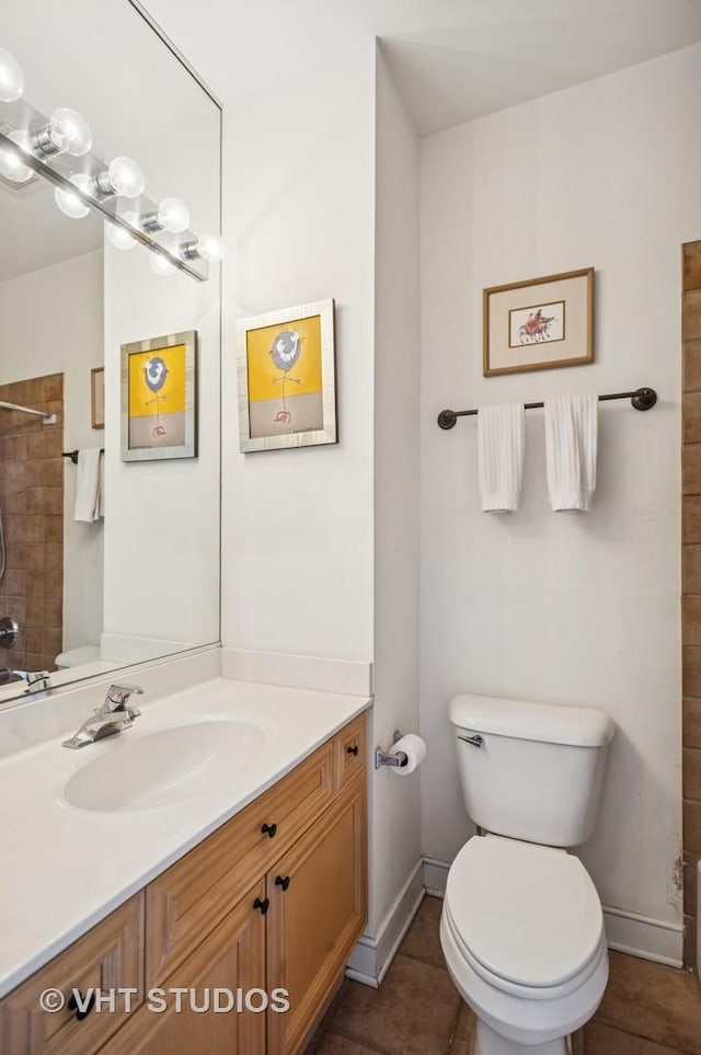 full bath featuring toilet, baseboards, tiled shower, tile patterned flooring, and vanity