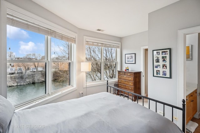 bedroom featuring a water view and visible vents
