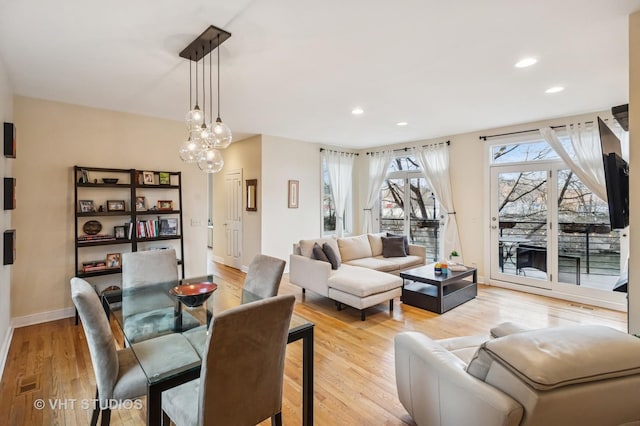 living room with recessed lighting, baseboards, light wood finished floors, an inviting chandelier, and visible vents
