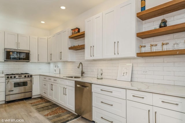 kitchen with open shelves, backsplash, stainless steel appliances, and a sink