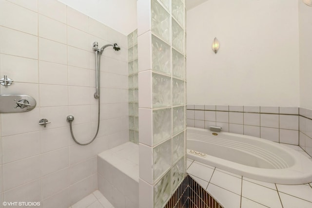 bathroom featuring tiled shower and a bath