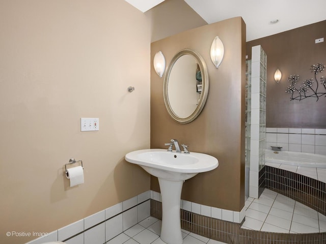 bathroom featuring tile patterned flooring and tiled tub