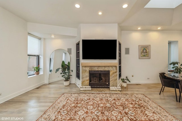 living room with a fireplace, recessed lighting, baseboards, and wood finished floors