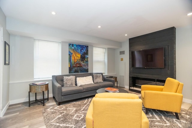 living room featuring wood finished floors, visible vents, baseboards, and recessed lighting