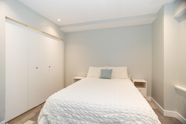 bedroom featuring baseboards, light wood-style floors, a closet, and recessed lighting